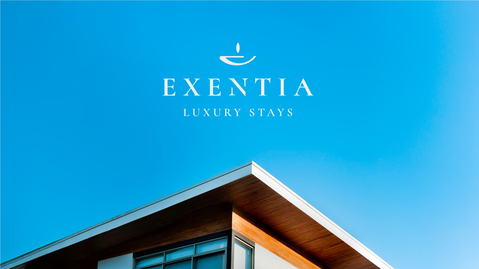 Exentia Luxury Stays logo against a blue sky above a modern house